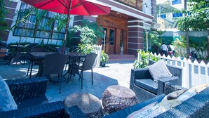 A hotel with outdoor seating and a red umbrella.