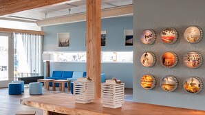Une pièce spacieuse avec une grande table en bois, des bancs et un mur décoré de cadres photo ronds.