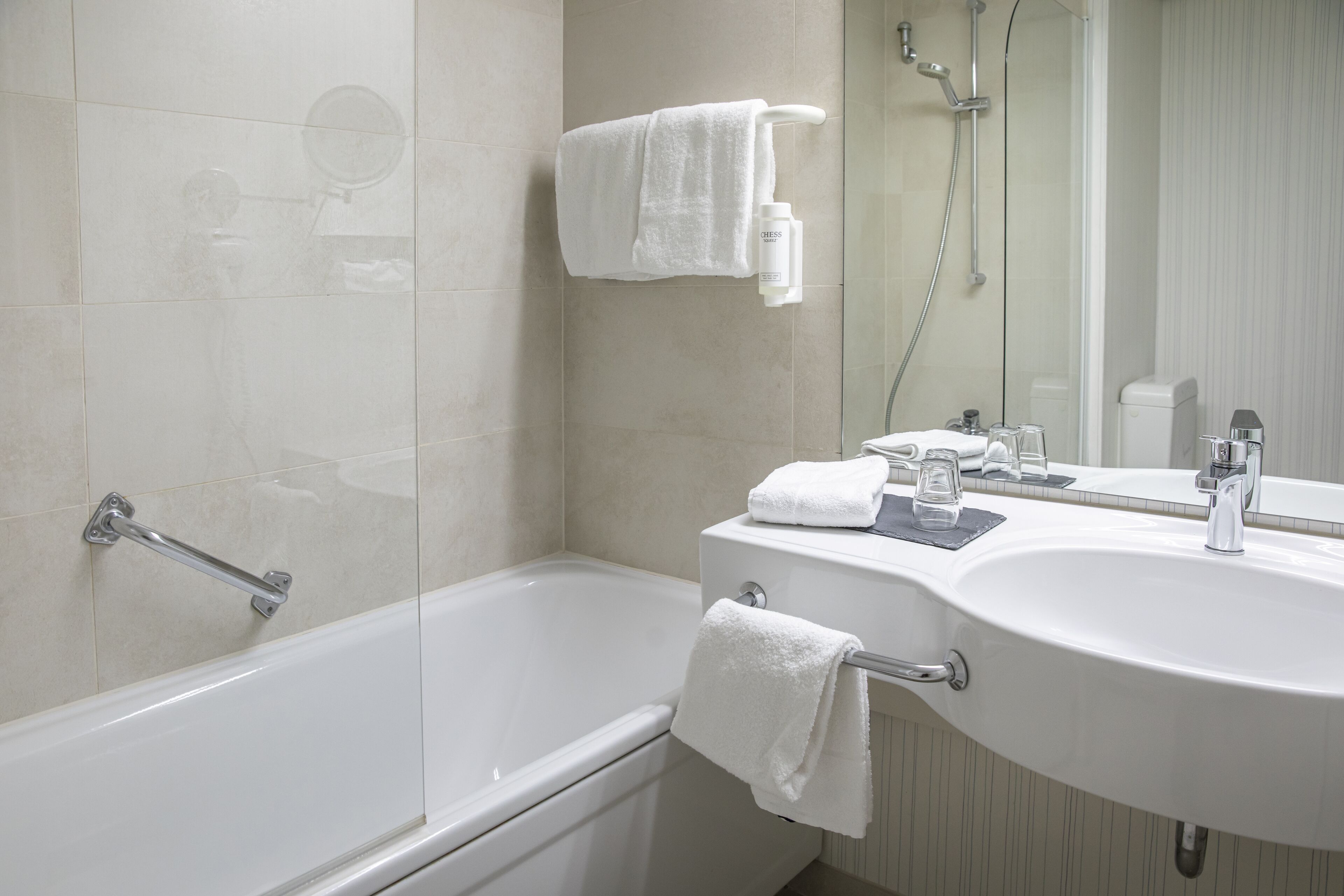 A modern bathroom with a bathtub, a sink with a mirror, and a shower.