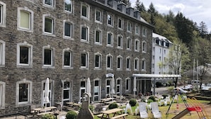A stone building with multiple windows and a sign reading "Stüwe".