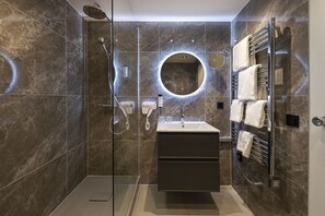 Superior tweepersoonskamer | Badkamer | Een bad/douchecombinatie, een haardroger, handdoeken