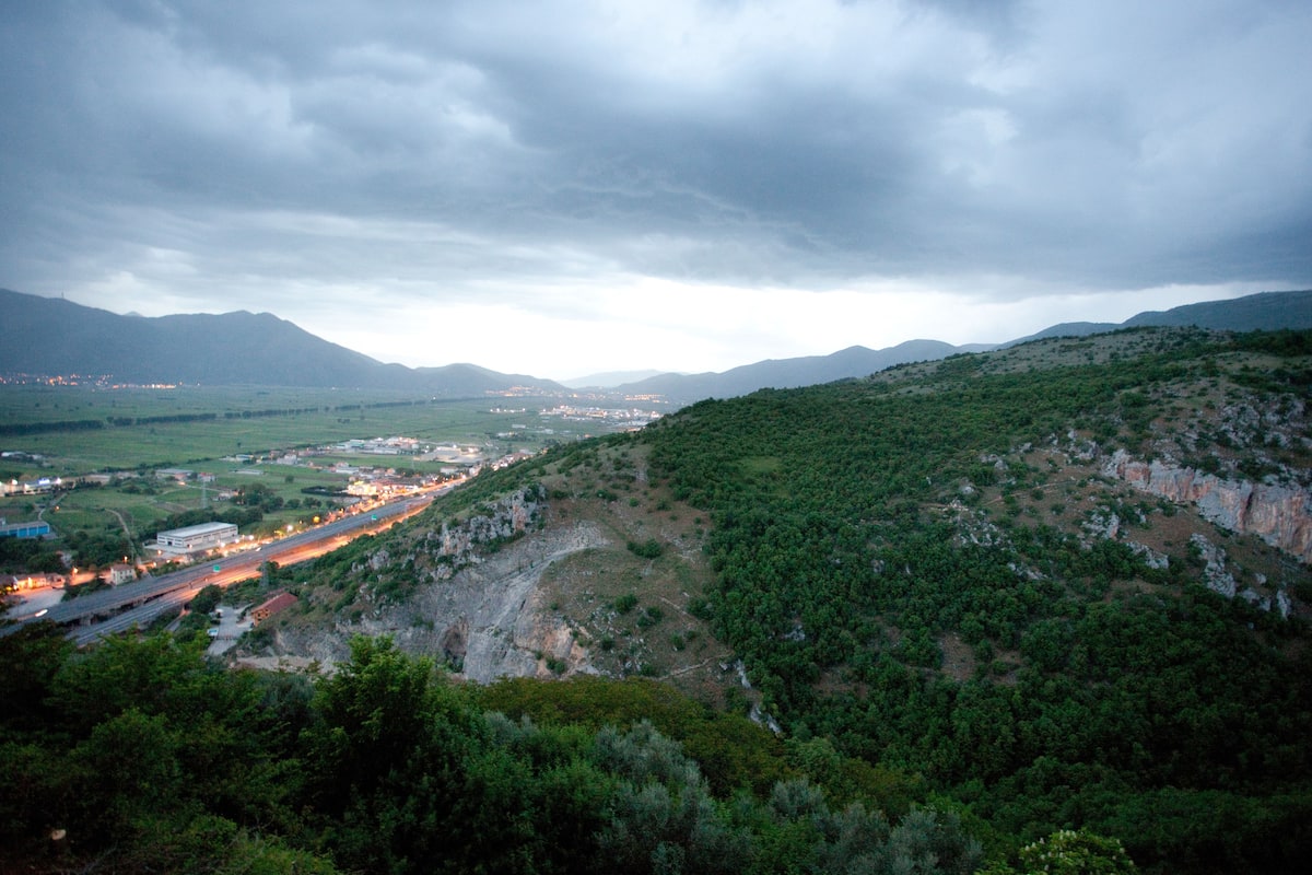A mountainous landscape with a road winding through a valley.