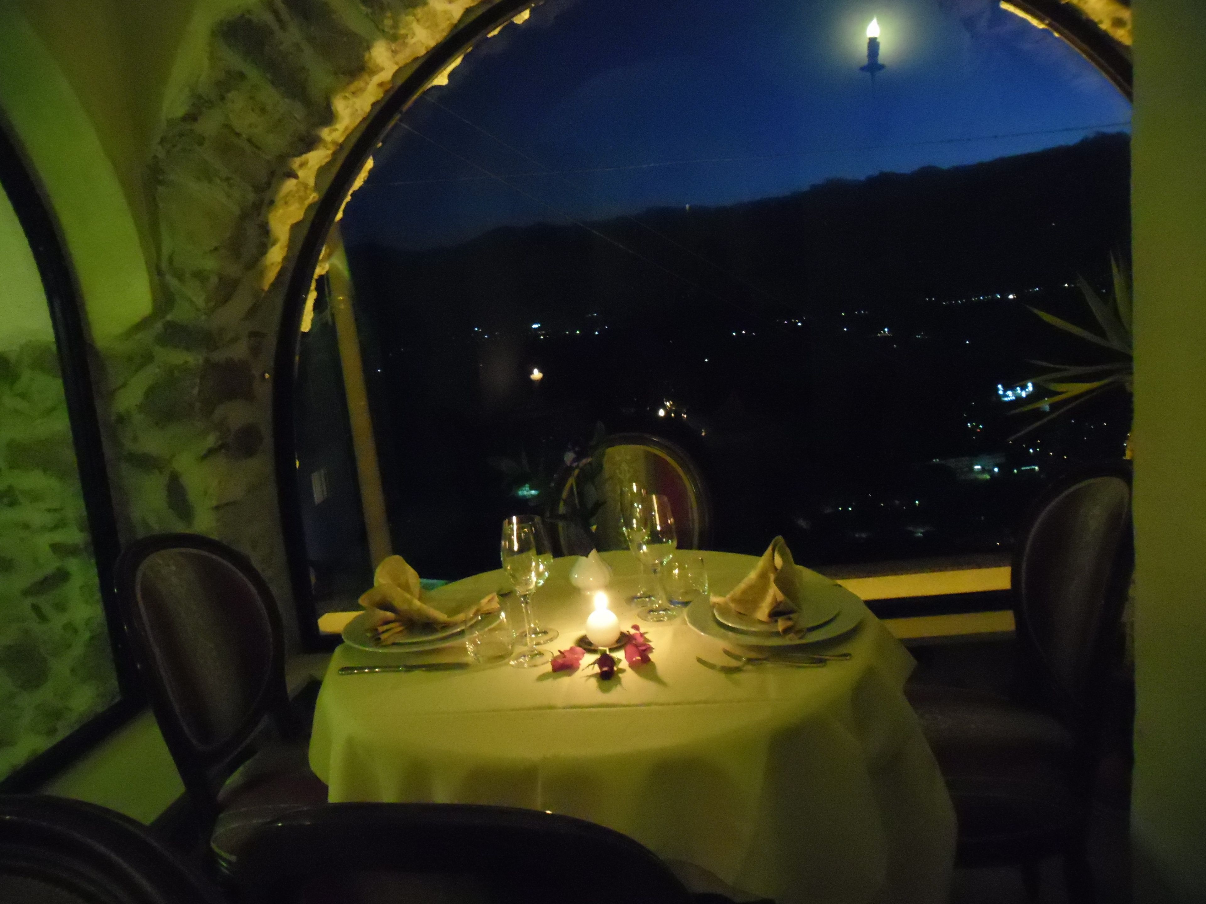 Ein Tisch für zwei Personen mit Blick auf den Nachthimmel und entfernte Lichter.