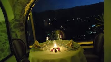 Ein Tisch für zwei Personen mit Blick auf den Nachthimmel und entfernte Lichter.
