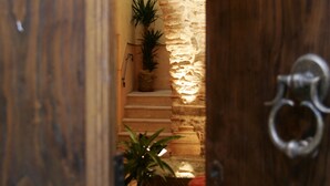 A wooden door with a metal handle, leading to a staircase with a stone wall and potted plants. - Hotel Villa Torre Antica (Atena Lucana)