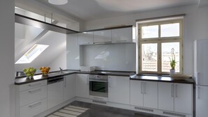 A modern kitchen with white cabinets, a built-in oven, and a large window providing natural light. - 1. Republic Hotel (Prague)