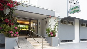A modern hotel entrance with a staircase, a sign reading "HOTEL JARDIM," and potted plants. - Hotel Jardim (Aveiro)