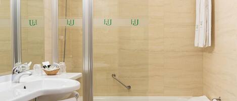 A modern bathroom with a shower, sink, and toilet.