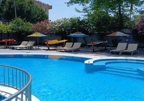 Ein Swimmingpool mit Liegestühlen und Sonnenschirmen.