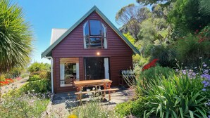 Une petite maison de plain-pied, dotée d’un toit à deux versants et d’un porche à l’avant.