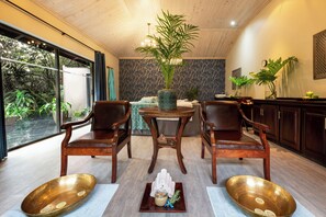 Una habitación con un ventanal grande, una mesa de comedor con sillas, una planta en maceta y un cuenco decorativo en el suelo.