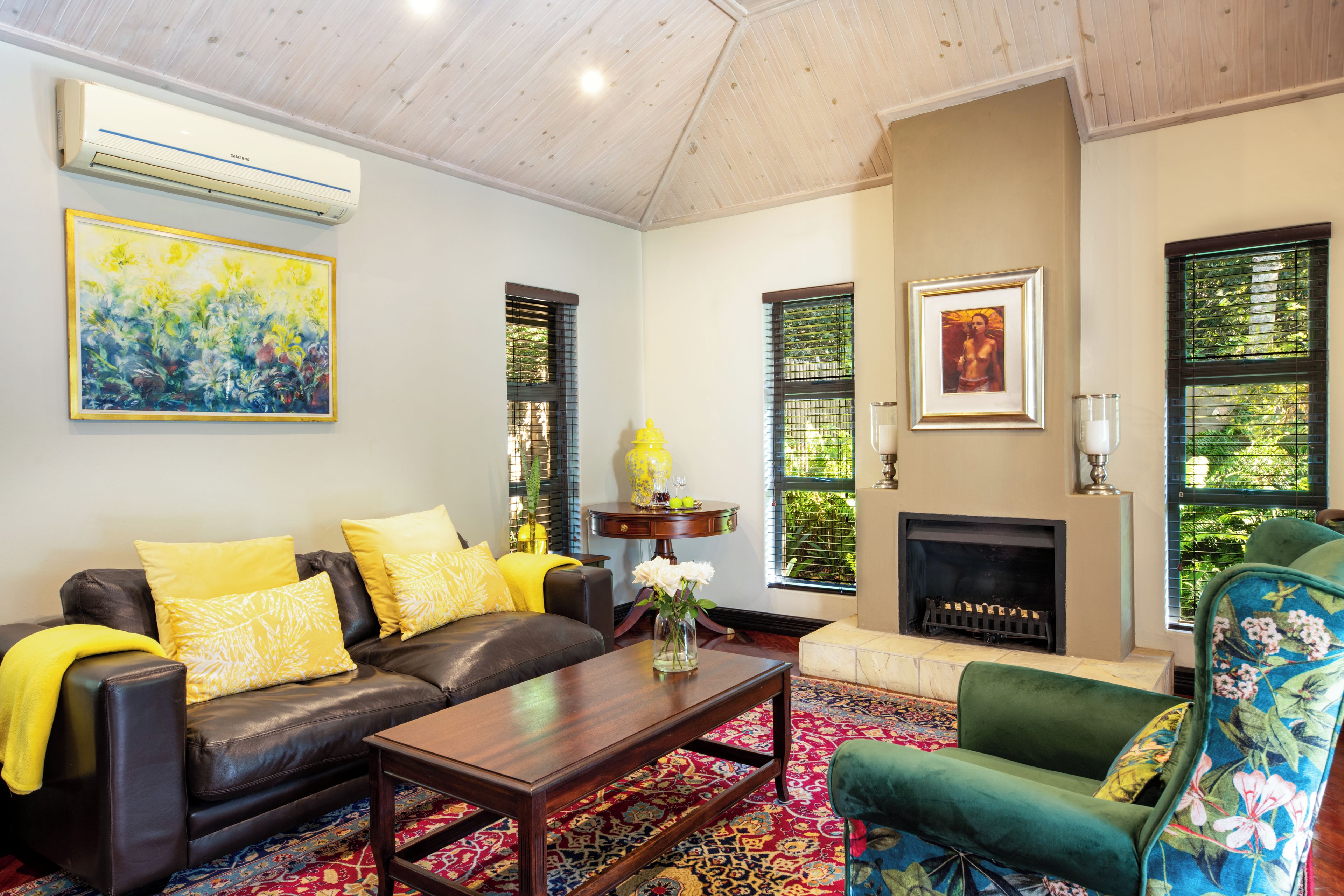 A living room with a fireplace, a sofa, a coffee table, and a green armchair.