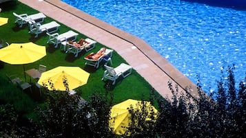 Una piscina cubierta, una piscina al aire libre, tumbonas