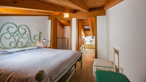 Un dormitorio con una cama, una silla y techo de madera.