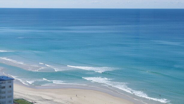 A beach with clear blue water and a sandy shore. - Marriner Views (Surfers Paradise)