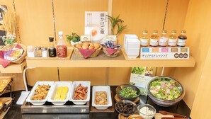 A buffet setup with various food items, condiments, and a sign indicating a Japanese theme.