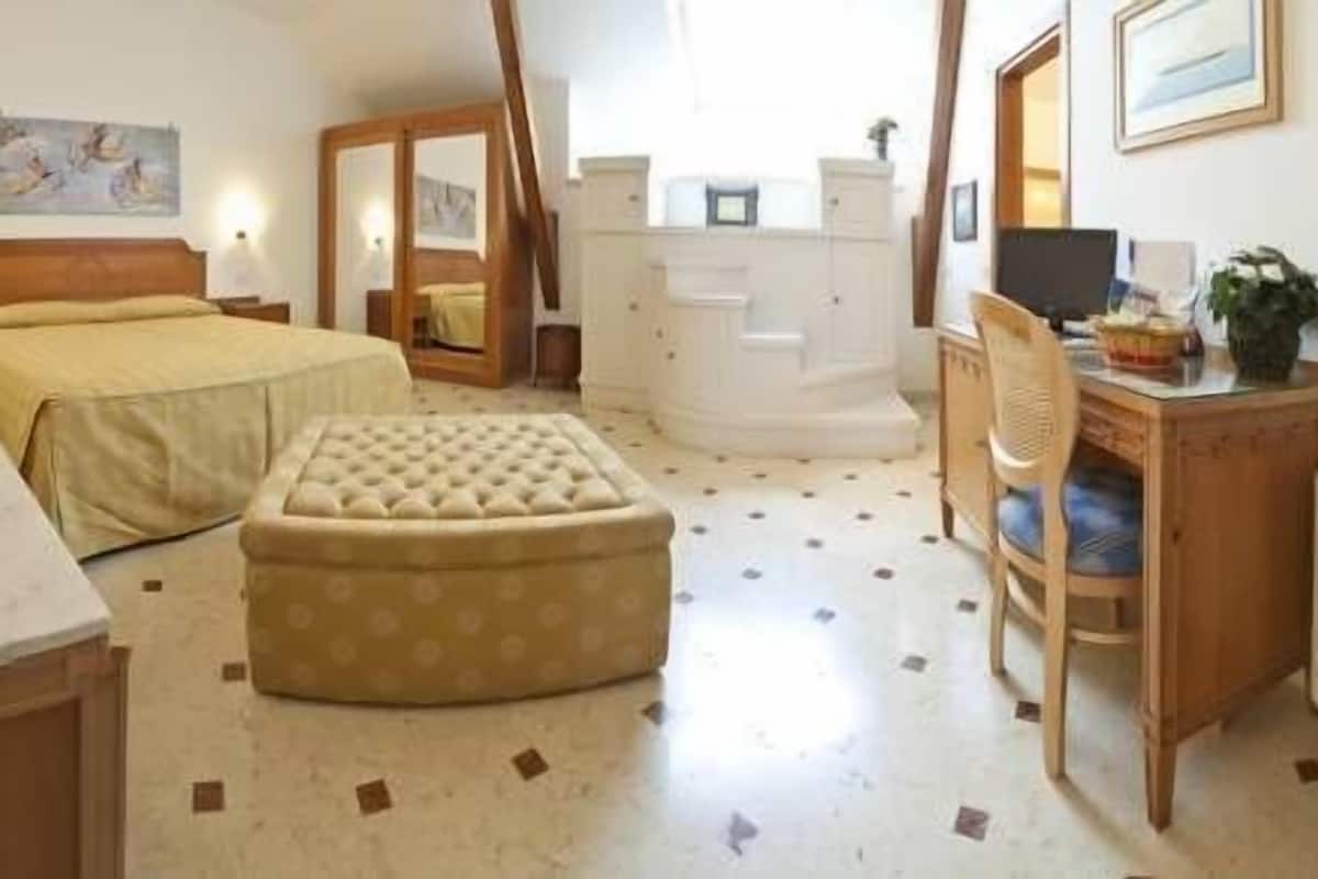Ein Schlafzimmer mit einem Bett, einer Kommode, einem Schreibtisch und einem Stuhl.