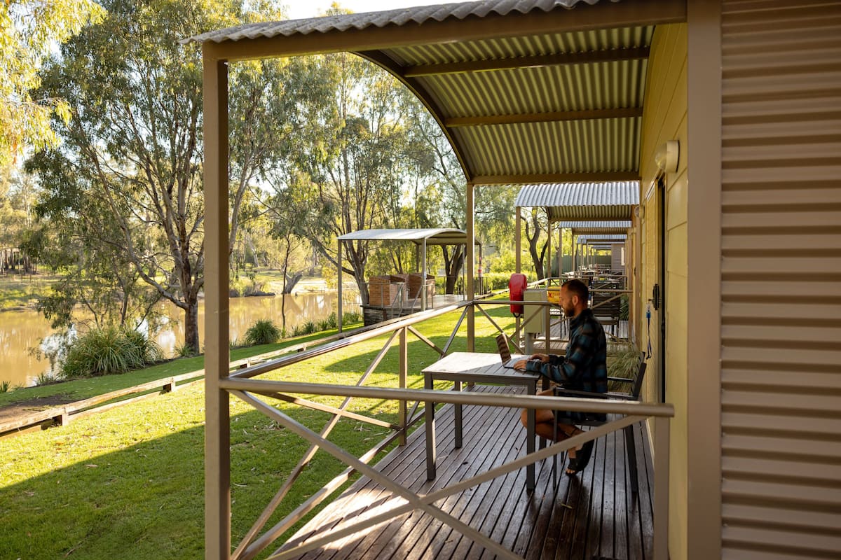 A covered outdoor area with a wooden deck, a table, and chairs.