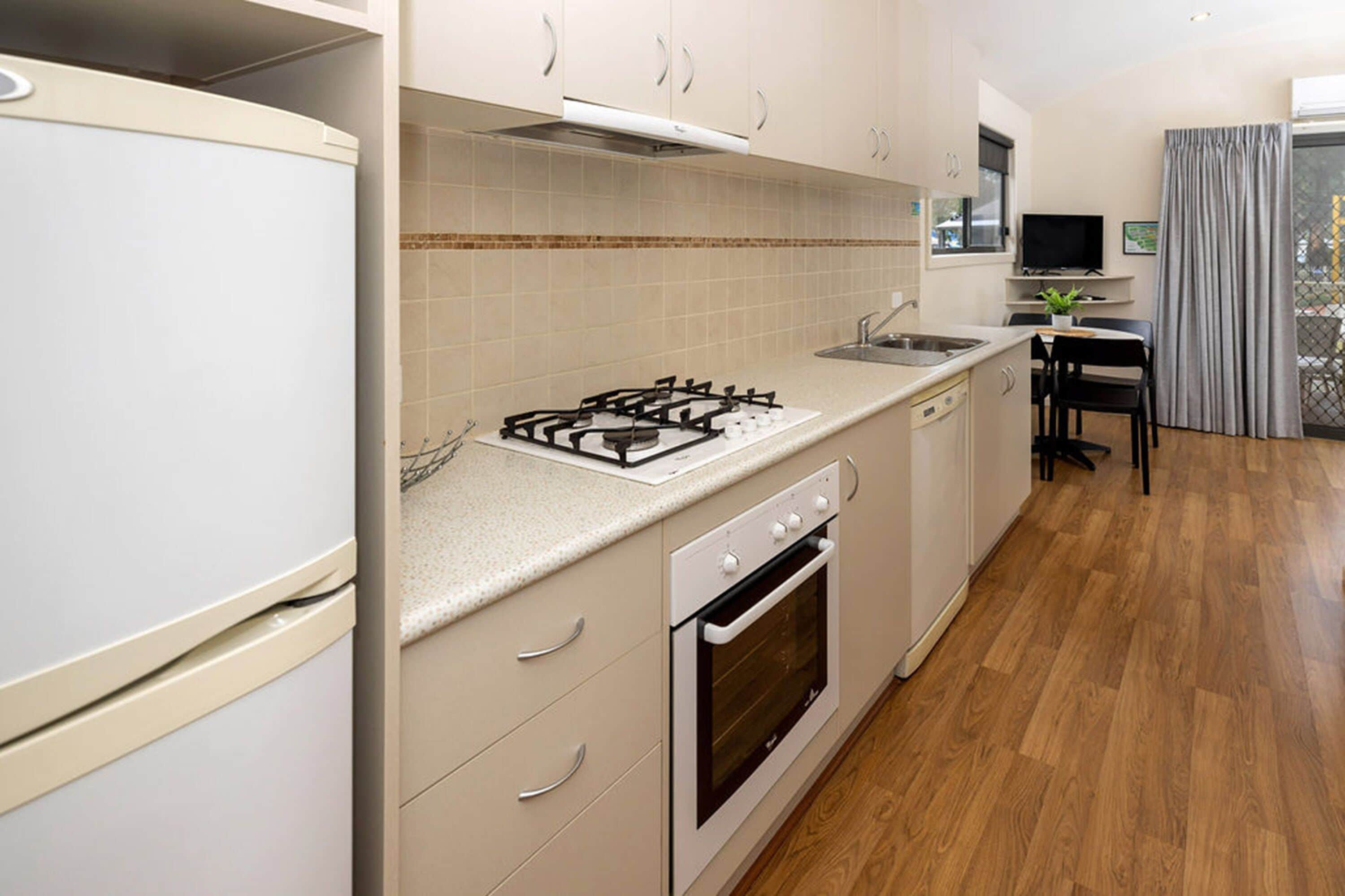 A modern kitchen with a gas stove, oven, and sink.