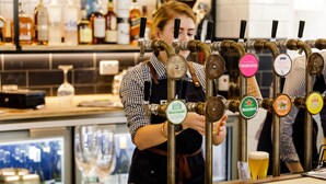 A bar with multiple taps labeled with beer names like "MOSCATO" and "ROSE."