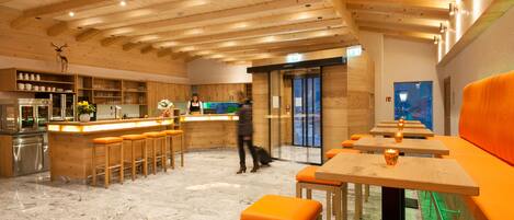 A modern interior with wooden beams, a bar area, seating, and a kitchen.