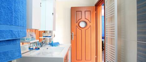 A bathroom with a sink, mirror, and toiletries.