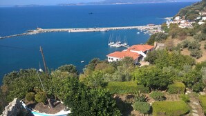 A coastal town with a marina, boats, and a white building with a red roof. - Aegean Wave Hotel (Skopelos)