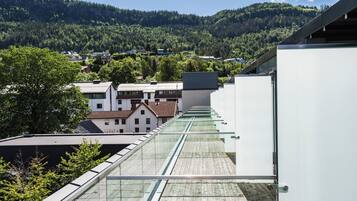 Enjoy a contemporary view of the surrounding neighborhood and forested hill from this building's glass facade.
