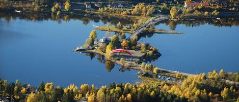 An aerial view of a lakeside town with houses, a bridge, and a boat dock.