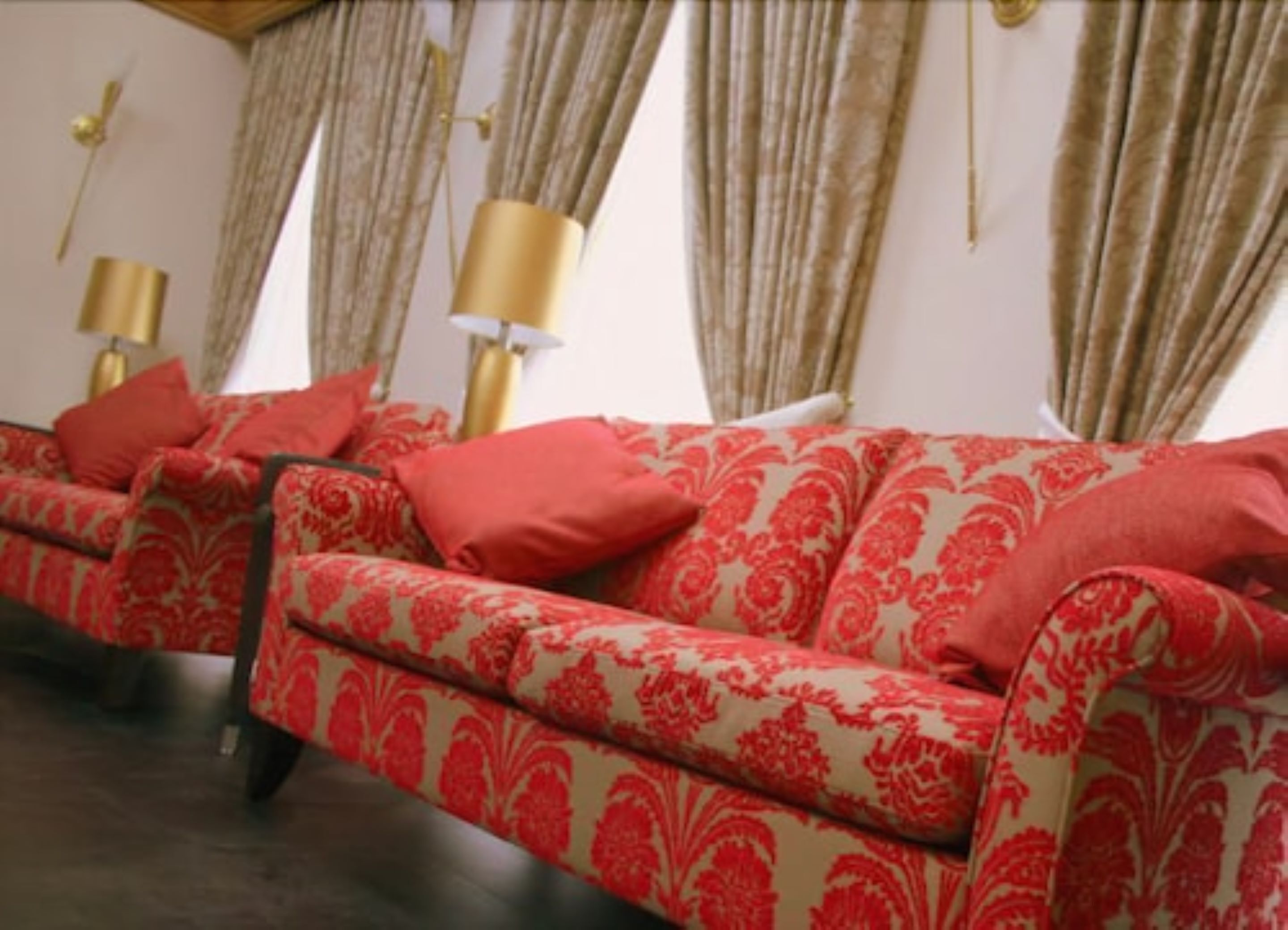 A room with a sofa set and a lamp.