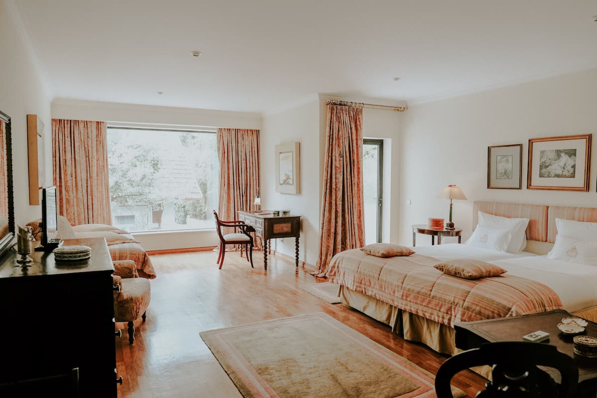 Un dormitorio con cama, escritorio, silla y vistas al exterior.