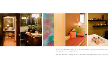 A spa room with a wooden floor, a large mirror, a plant, and a colorful abstract painting.