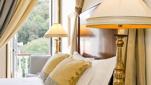 Una habitación de hotel con una cama, dos lámparas y cortinas.