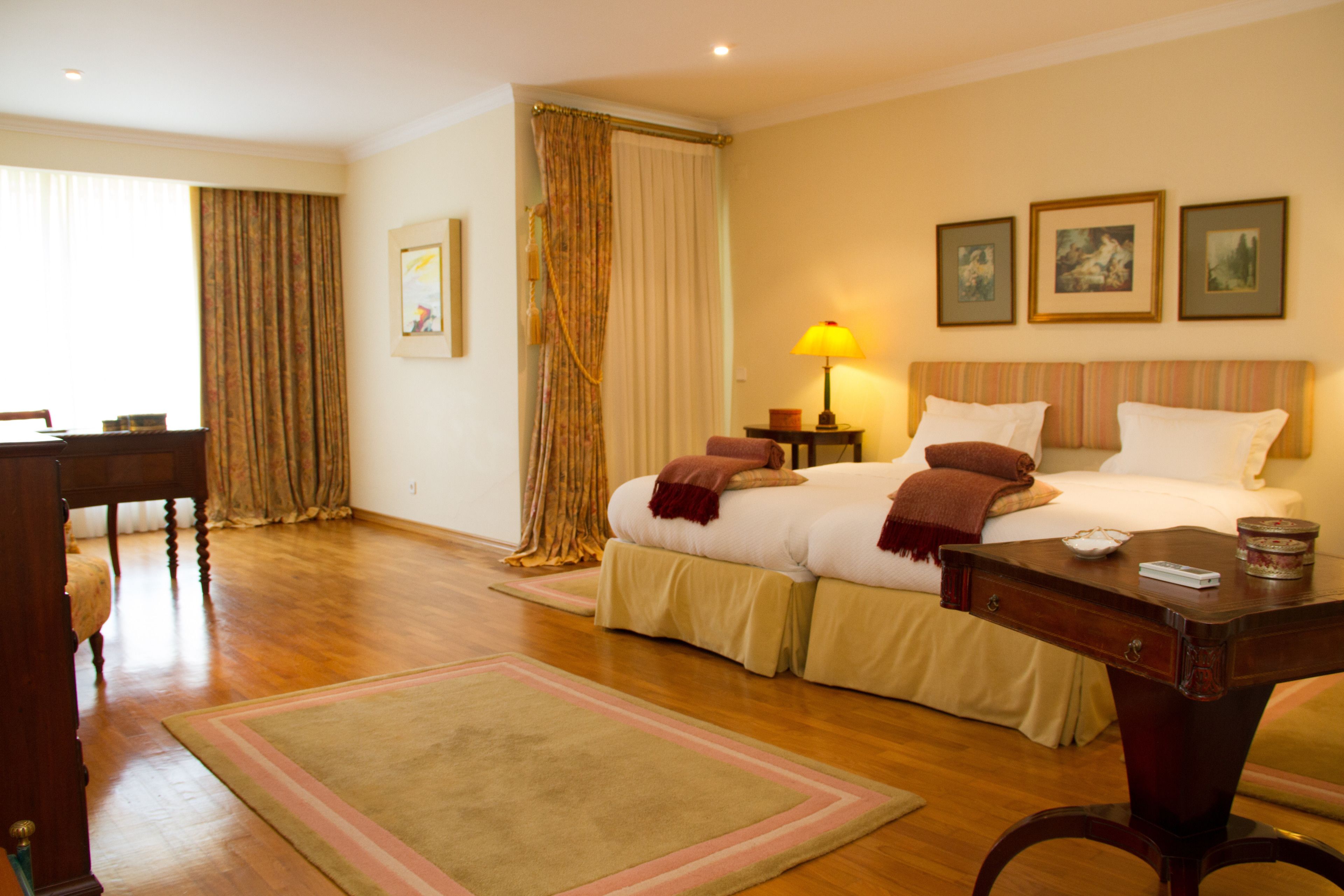 Una habitación de hotel con cama, mesitas de noche, escritorio y una silla.