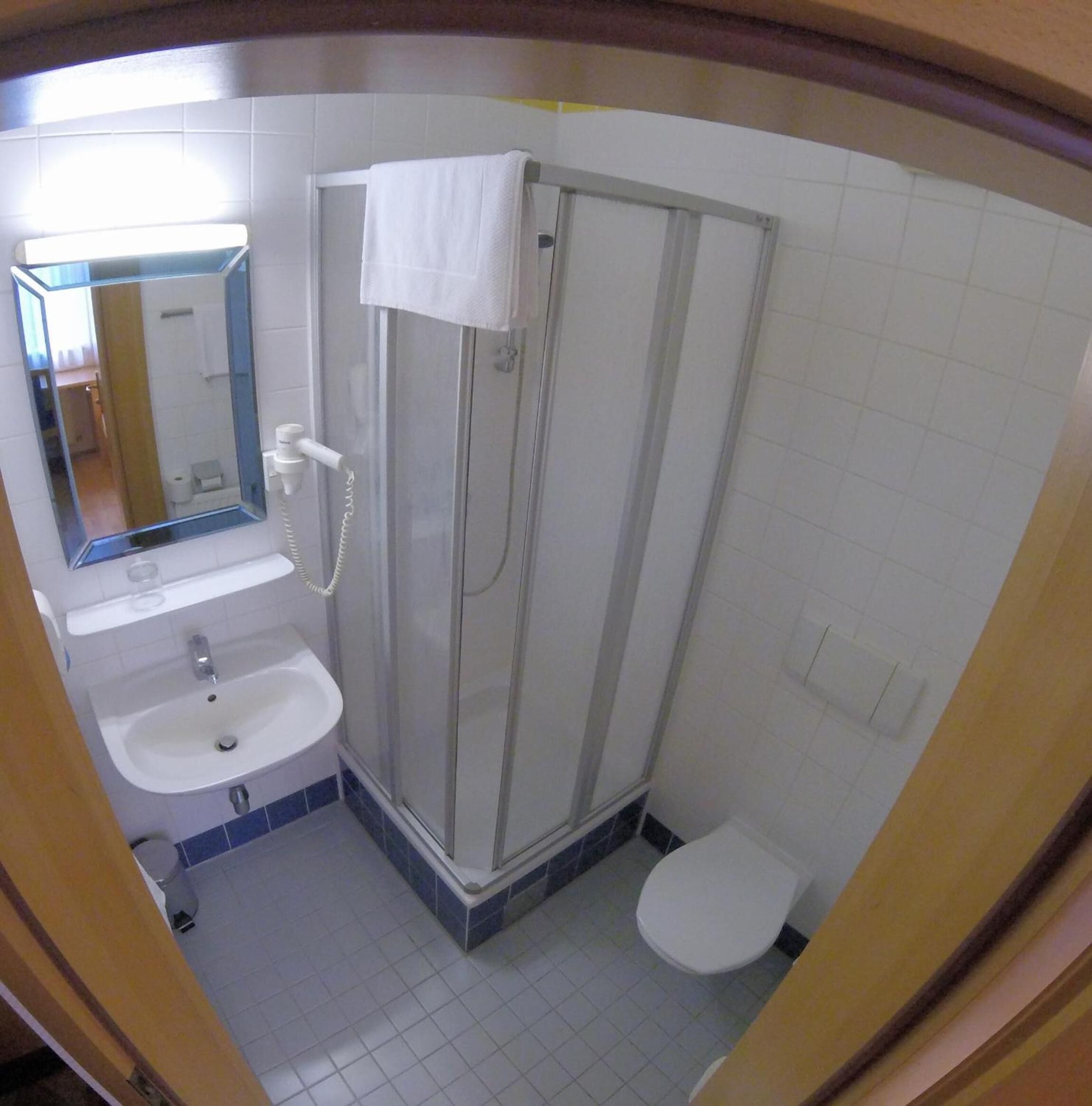 A bathroom with a shower, sink, and toilet.