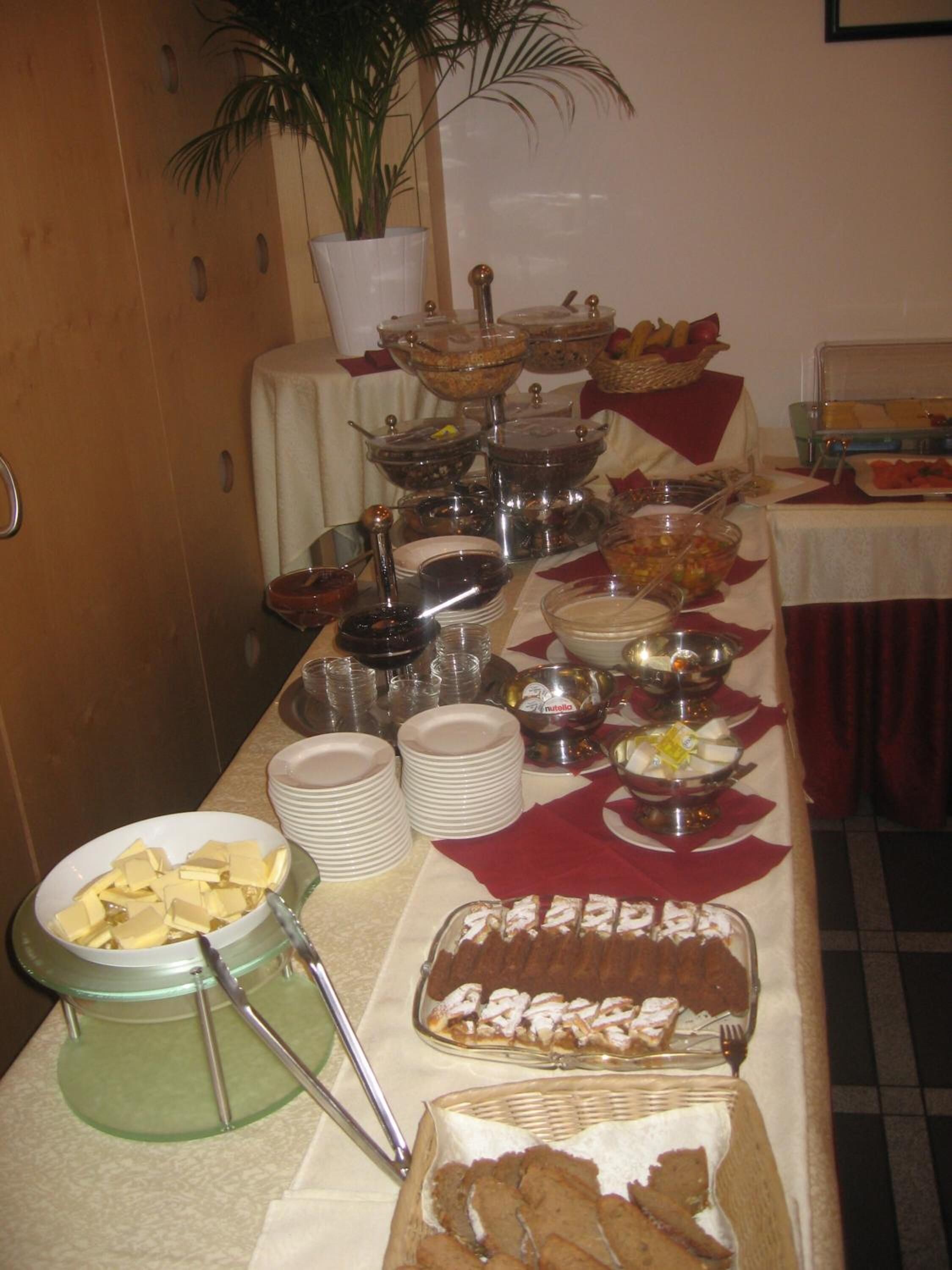 A buffet table with various food items and serving utensils.