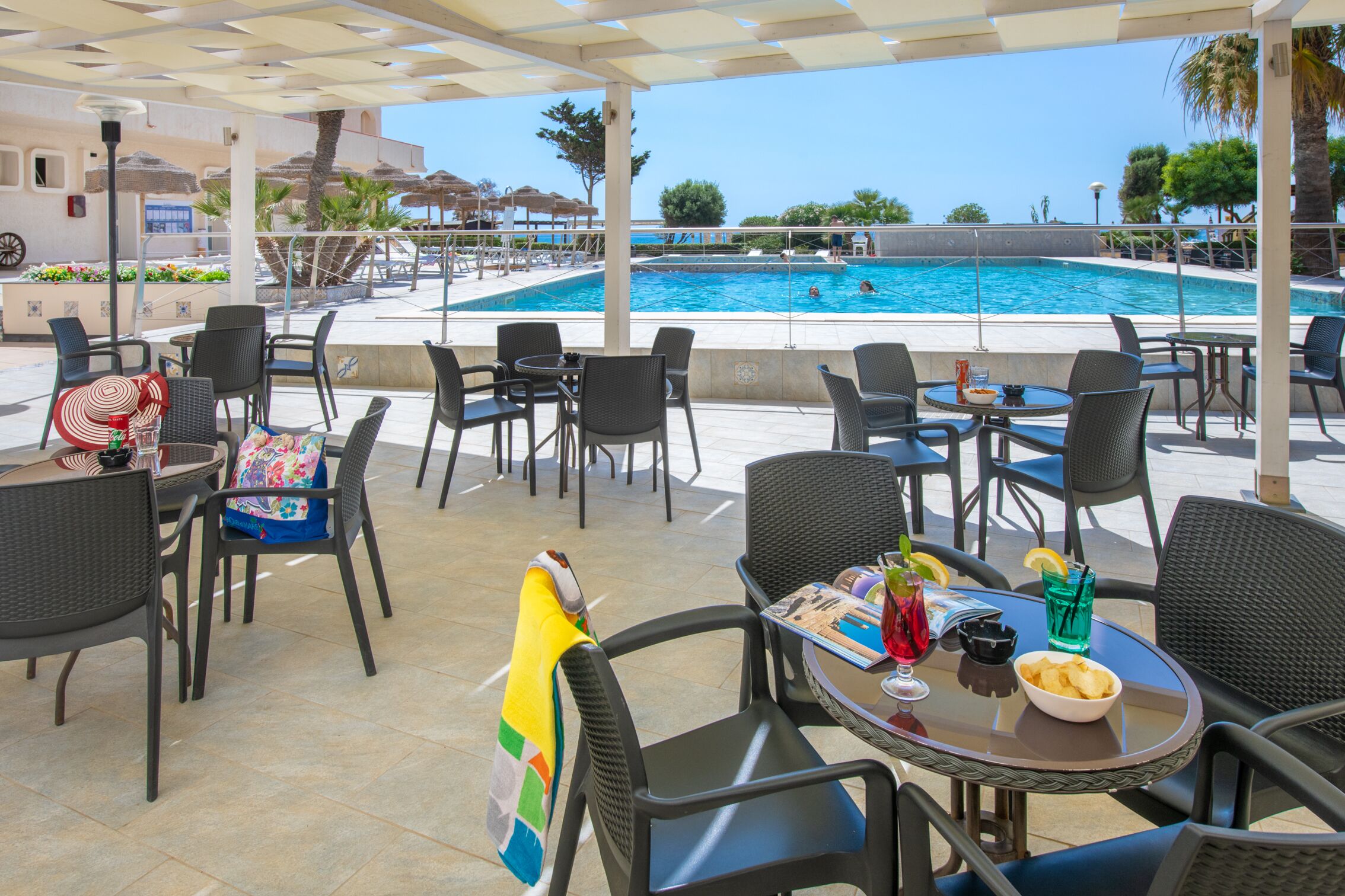 A poolside area with outdoor seating and a view of the pool.