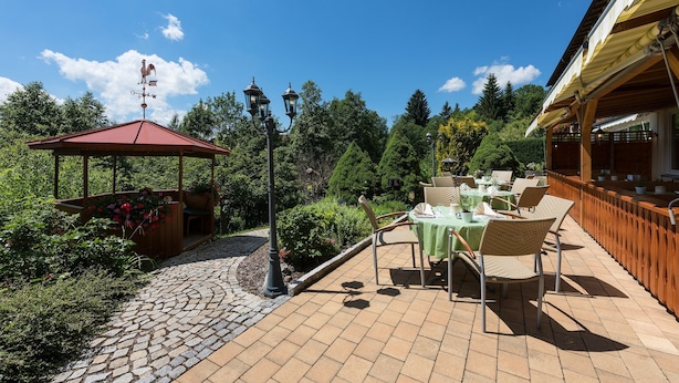 A patio area with outdoor seating, a gazebo, and a weather vane.