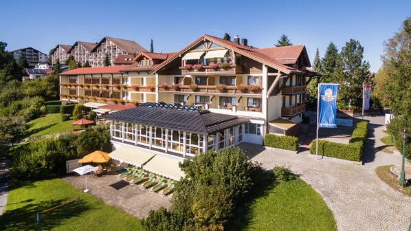 A multi-story hotel with balconies, a covered patio area, and a flag indicating a ski resort.