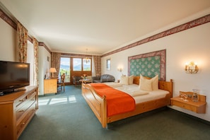 A hotel room with a bed, a TV, a desk, and a chair.