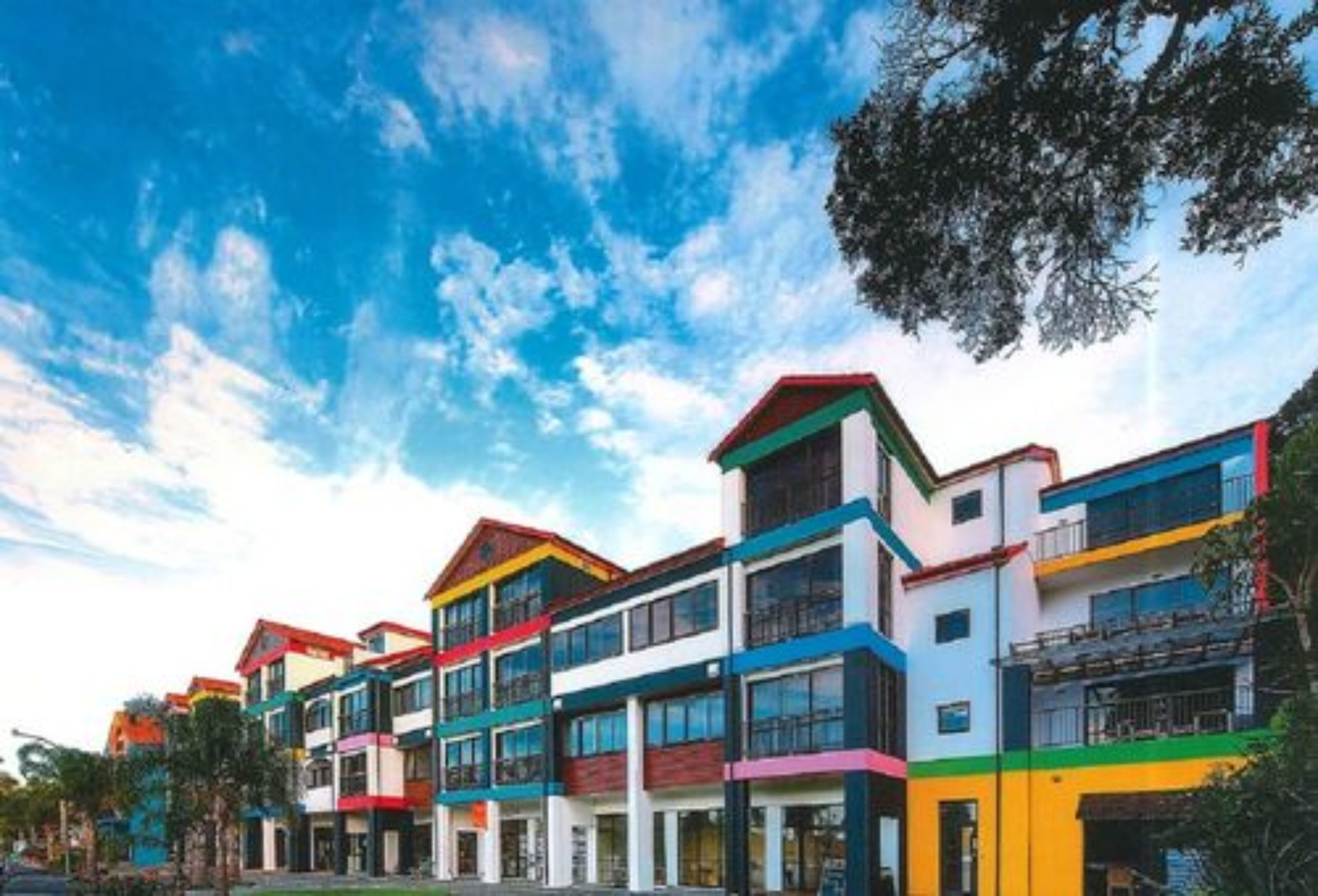 Un edificio de varios pisos con un diseño arquitectónico moderno, con balcones y ventanas amplias.