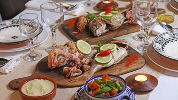 A dining table set with plates, glasses, and a variety of seafood dishes.