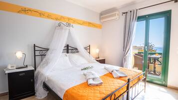 A bed with a canopy, a bedside table with a lamp, and a view of the outside through a glass door.