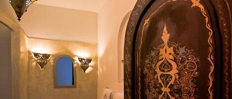 A bathroom with a sink, mirror, and decorative wall sconces.