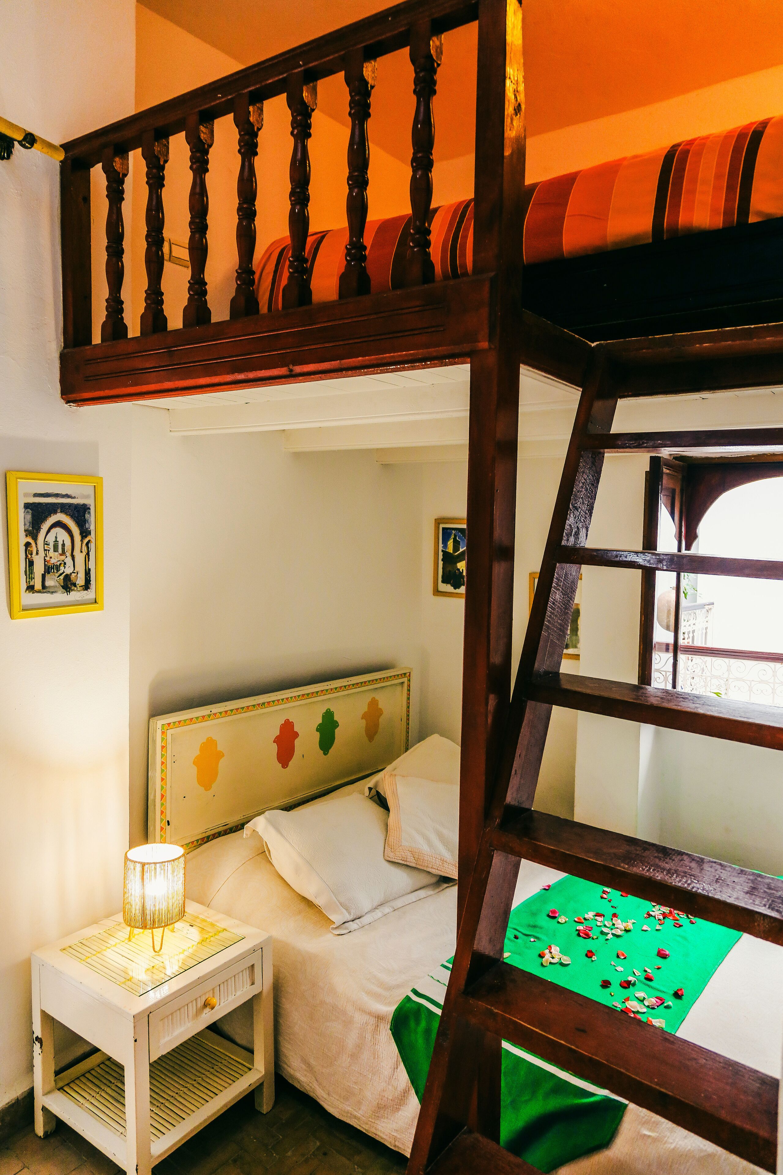 Una camera da letto con una cuccetta, un comodino con una lampada e un tappeto verde sul pavimento.