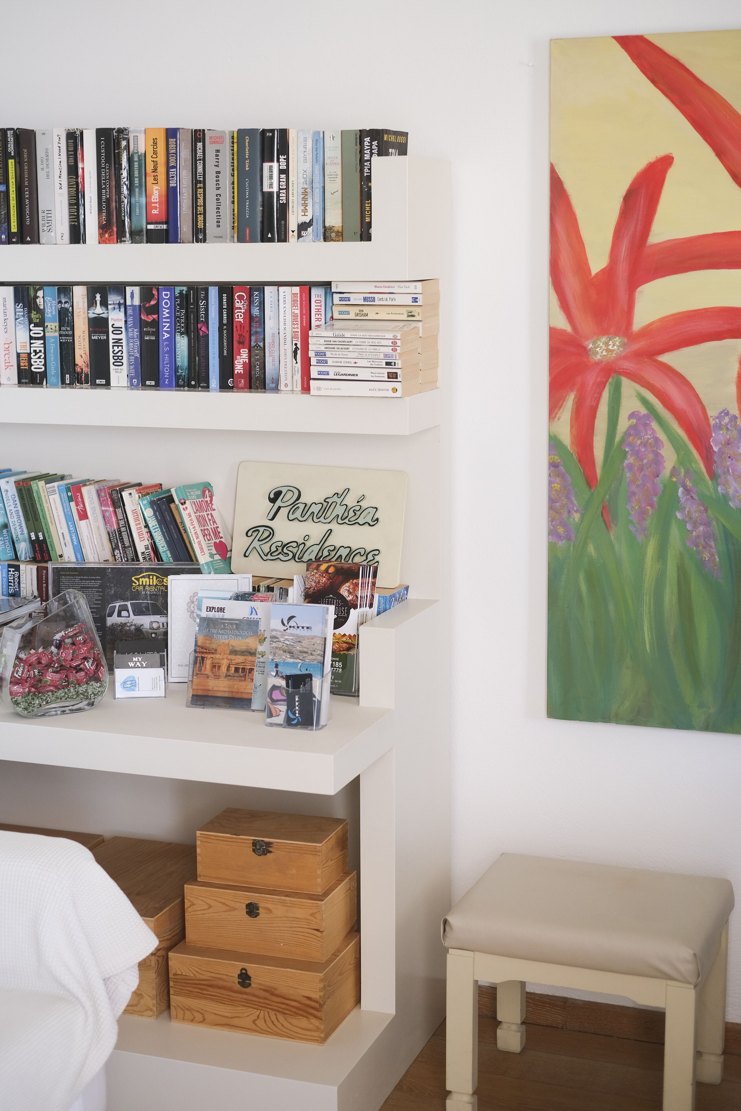 Une bibliothèque remplie de livres, un panneau encadré et un tableau.