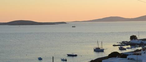 A coastal view with boats, a small island, and white buildings.