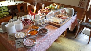A buffet table with various food items and serving utensils. - Hotel Gasthof zum Schwan (Steinsfeld)