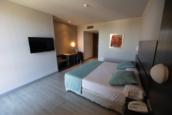 Una habitación de hotel con una cama, mesita de noche y teléfono.