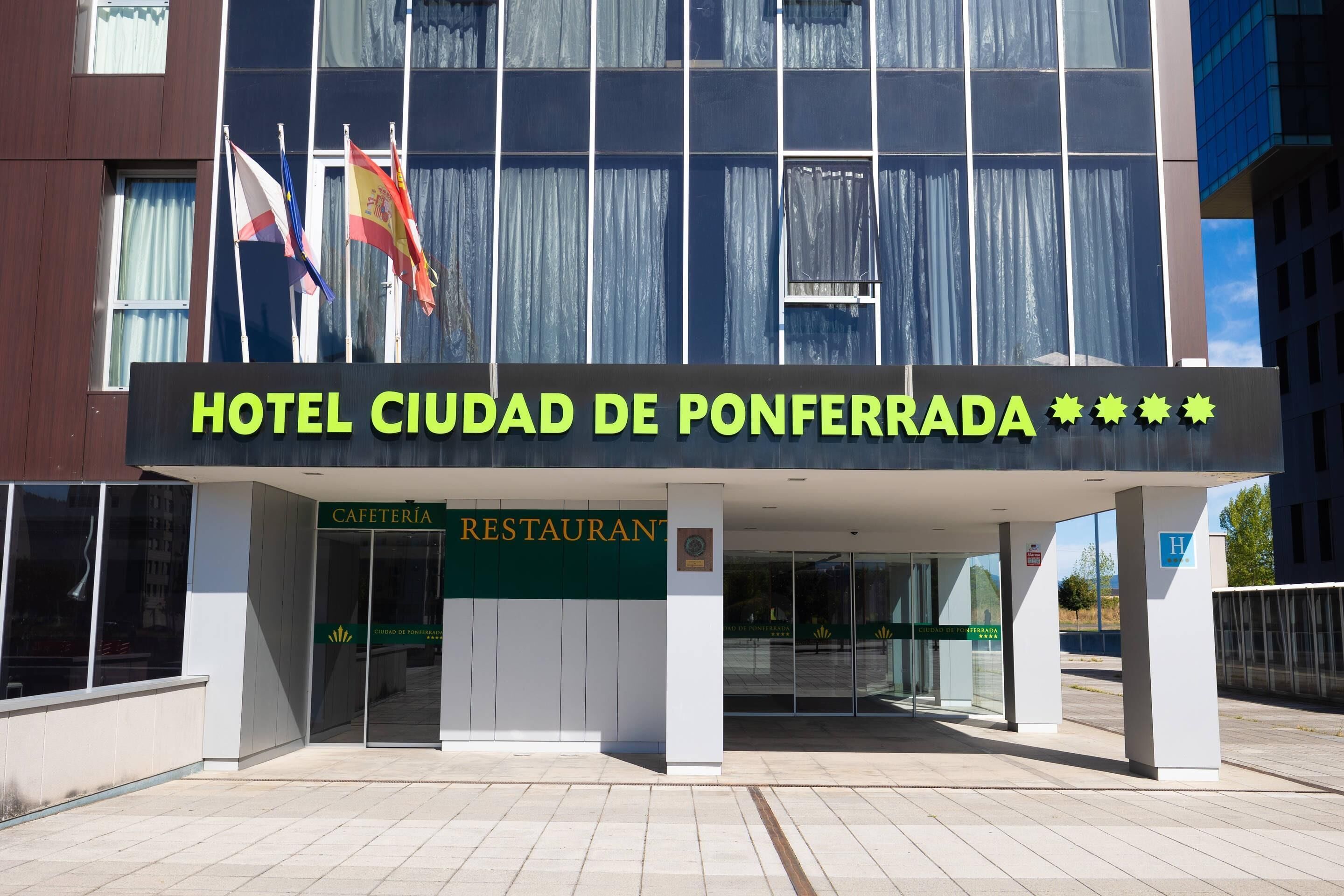 A hotel entrance with a sign reading "HOTEL CIUDAD DE PONFERRADA" and a "CAFETERIA RESTAURANT" sign below.